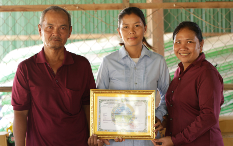 Man and 2 woman posing with a ceritificate