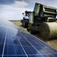 tractor with hay next to a solar panel