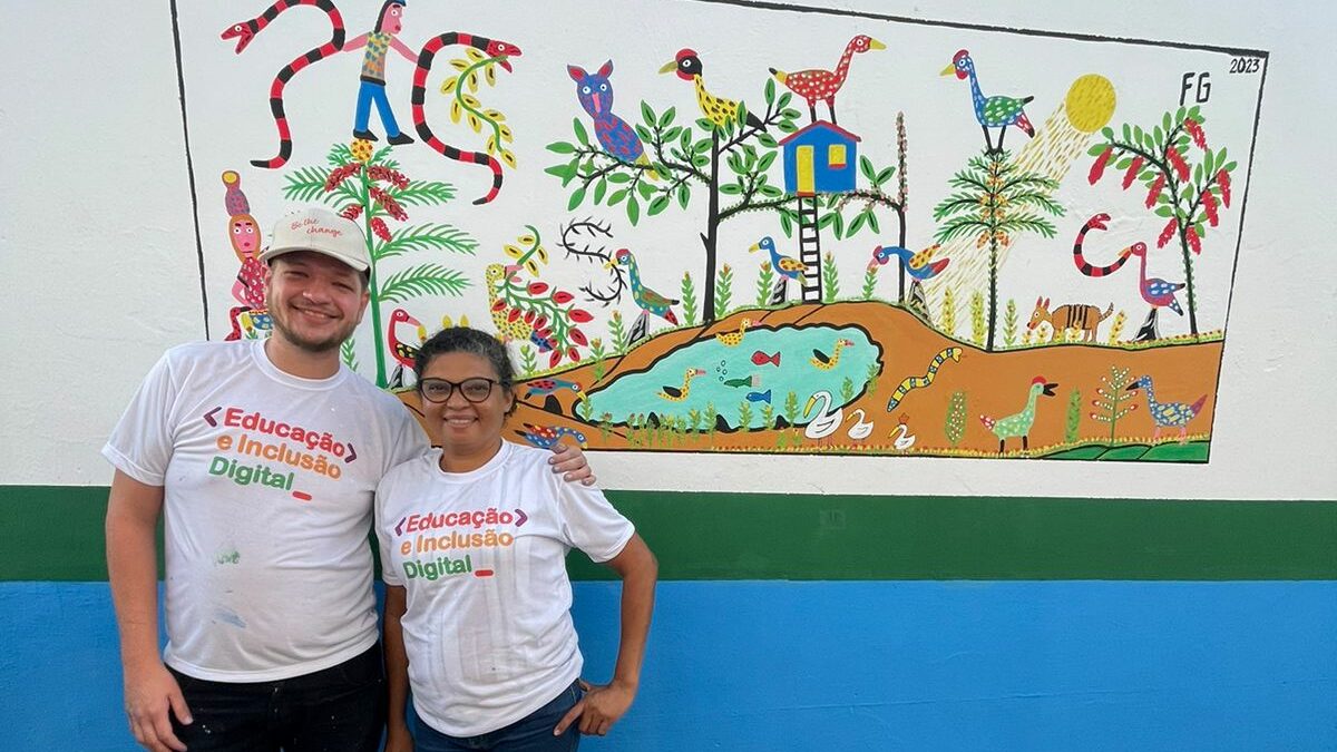 Brazil team volunteers smiling in front of finished painted wall mural