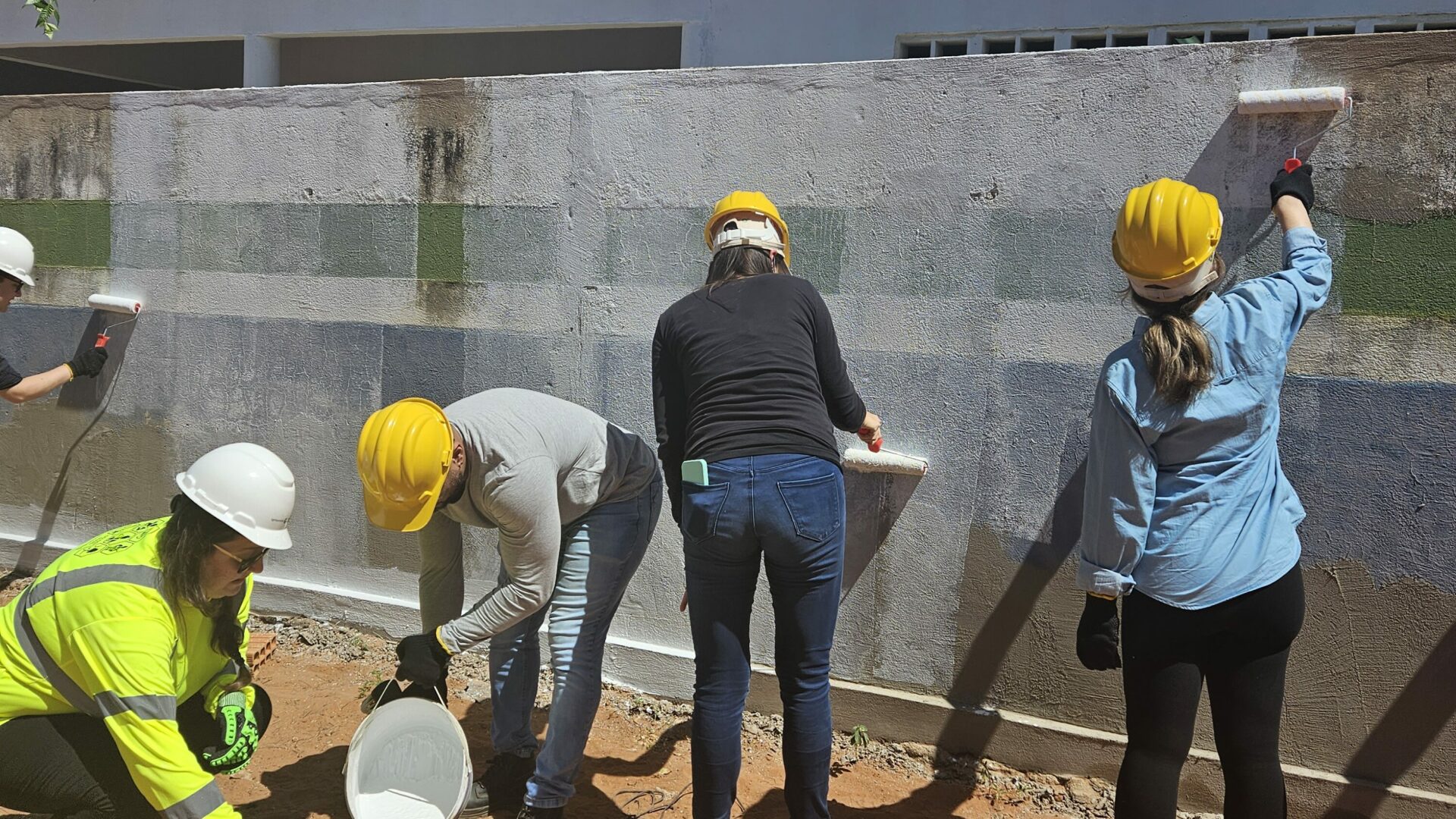 Brazil team volunteers painting a wall