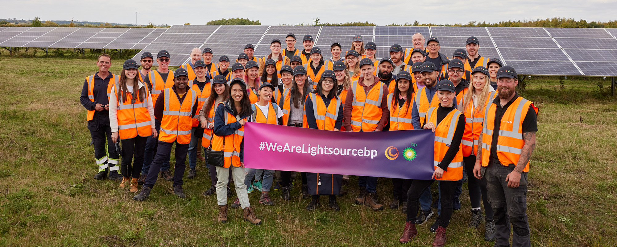 Lightsource bp team members on site holding a banner