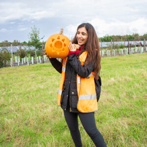 Lightsource bp team member holding her carved pumpkin at Manor Farm solar site