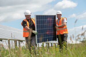 Lightsource bp O&M team members carrying a solar panel