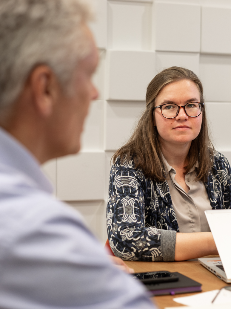 Woman with glasses looking at a man in the office