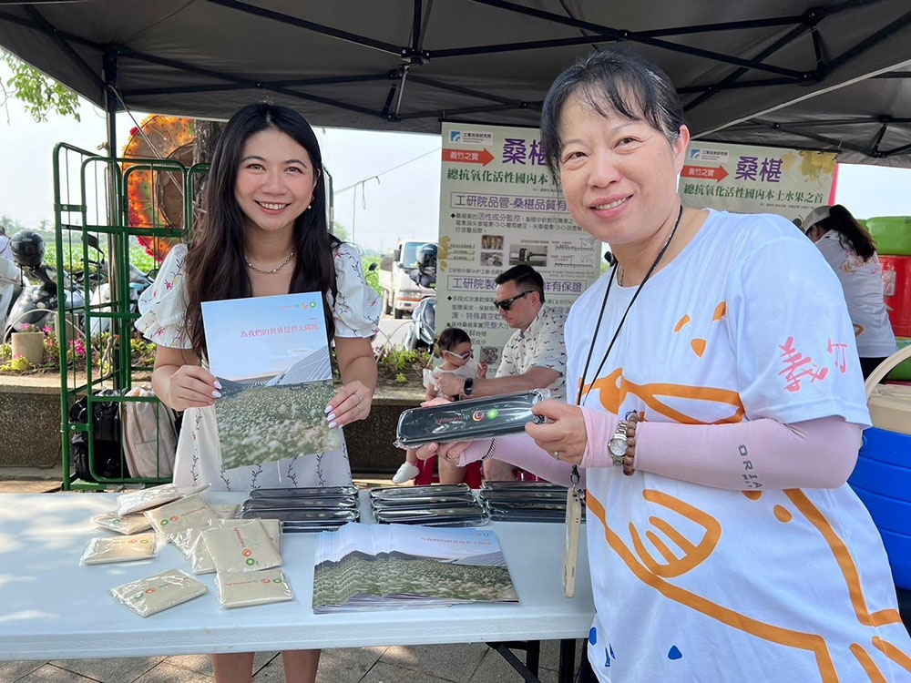 Vivi Lee at a community event holding Lightsource bp branded items and a brochure